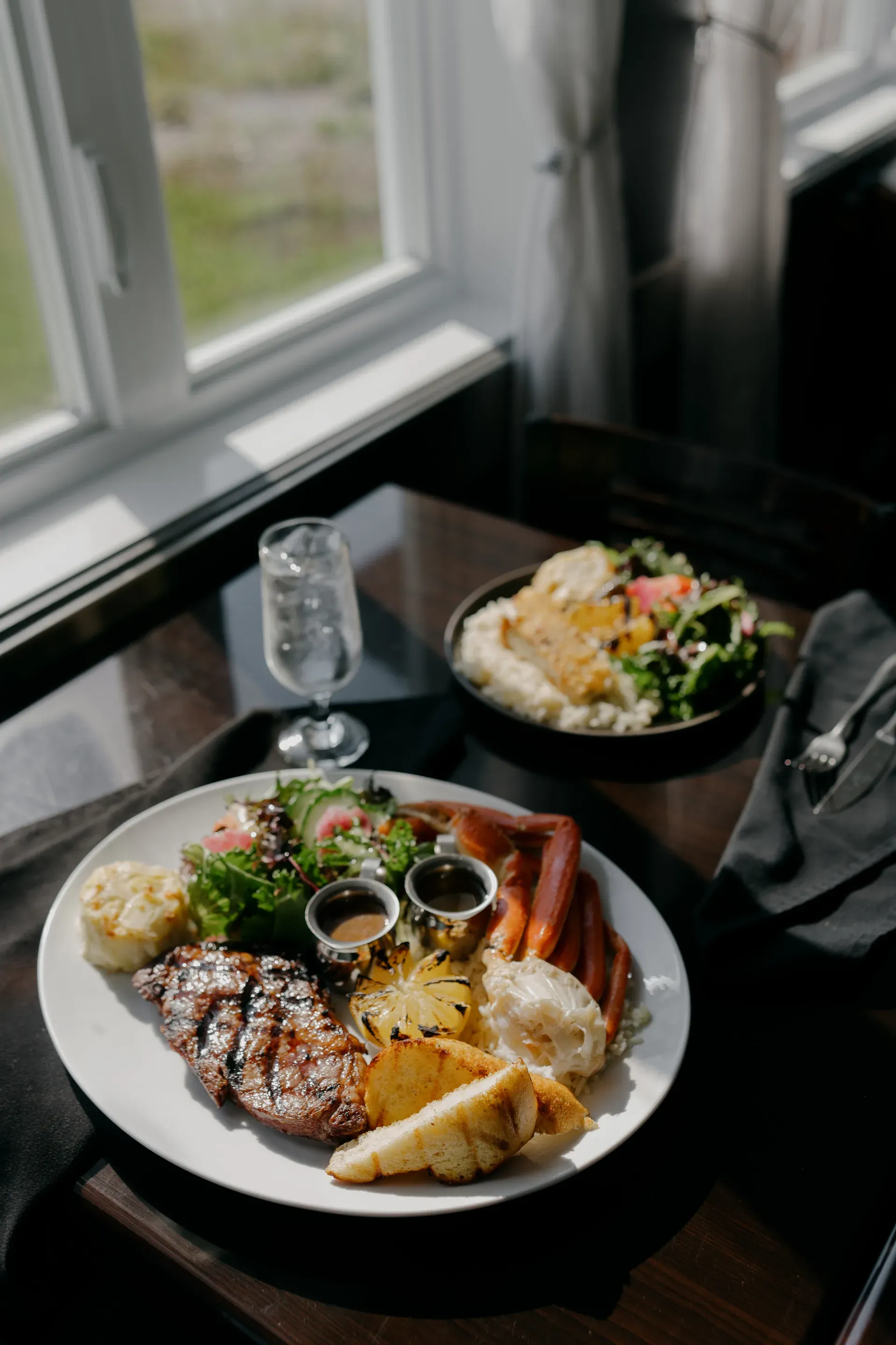 Assiette surf and turf servie au restaurant Pêcherie Manicouagan, avec vue sur le fleuve Saint-Laurent